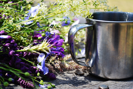 Metal mug on a table with beautiful blooming flowers, filter,の写真素材