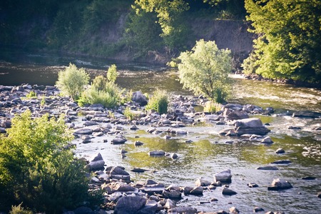 small river with rocky shores and trees, filterの写真素材