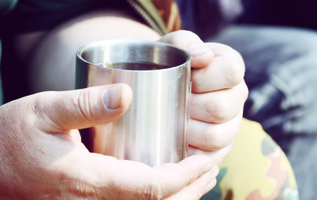 man holding a metal cup closeup, filter,の写真素材