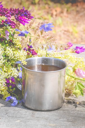 spring flowers with an iron mug on a tabl, filterの写真素材