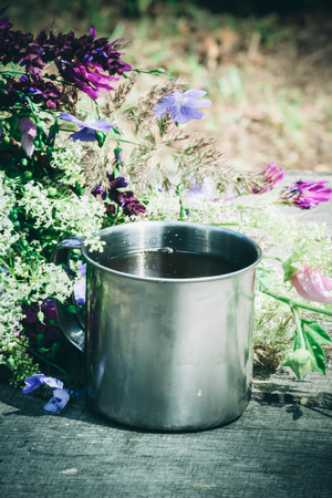 spring flowers with an iron mug on a tabl, filterの写真素材