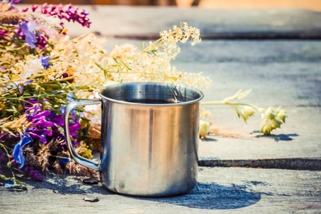 mug of coffee or tea with flowers is on the tableの写真素材