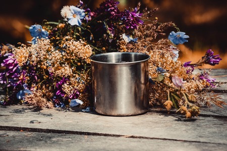 Mug for a tourist on a table with flowersの写真素材