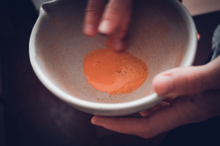 mixing the natural yellow pigment in a plate with a finger