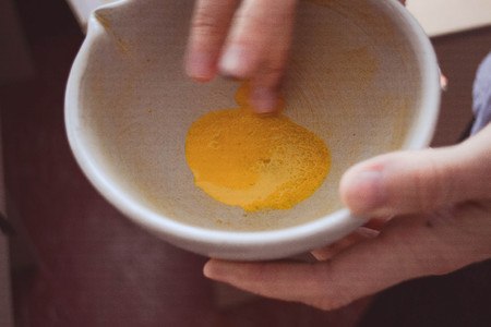 mixing the natural yellow pigment in a plate with a fingerの写真素材