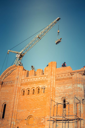 construction of a brick building on a sunny day with blue skyの写真素材