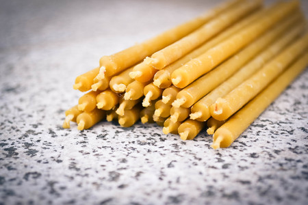 many thin wax candles lie on the backgroundの写真素材