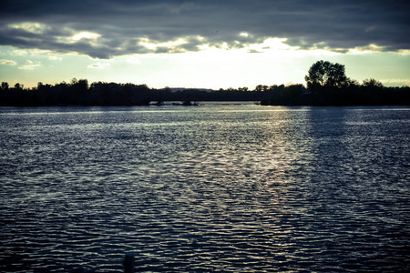 dark clouds at sunset, sunrise above the water surface, filterの写真素材