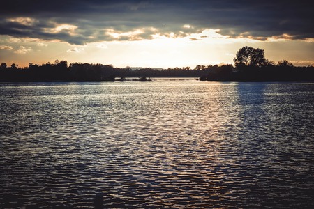 dark clouds at sunset, sunrise above the water surface, filterの写真素材