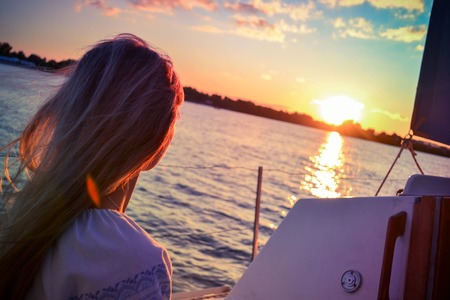 girl on the boat watching the sunset with filterの写真素材