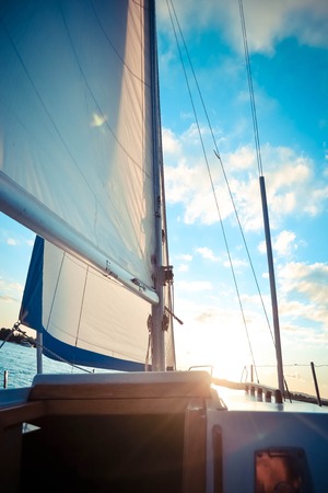 mast yacht at sunset, Sailboat on sunset, luxurious water transport,  evening travel on sail yacht,  yachting sport conceptの写真素材