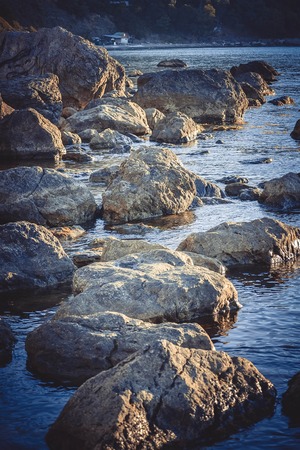 Large stones in the water near the shore, filterの写真素材
