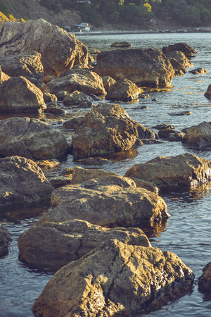 Large stones in the water near the shore, filterの写真素材