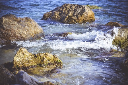 group of stones in water with white foamの写真素材