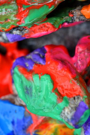 rocks covered with colorful paint close-up. Stones in the paint with streaks. Abstract backgroundの写真素材