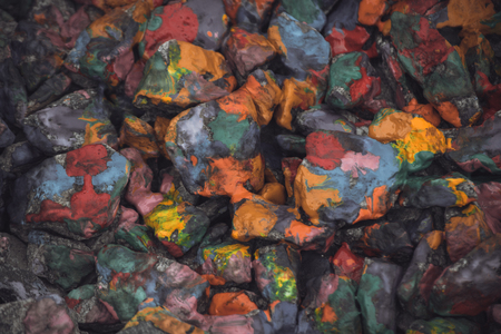 abstract background of the plane lying on colored stones close-up,. Many stones painted with colored inksの写真素材