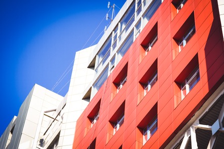 facade, front of the large house red and gray in the high-tech style on a bright sunny day on blue sky backgroundの写真素材