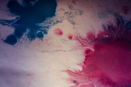 pink and blue flowed blots on white paperの写真素材
