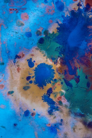 Drops with streaks of different colors of paint are mixed and absorbed. Abstract paint stains on white paperの写真素材