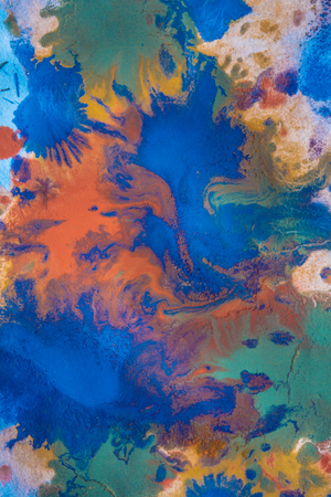Drops with streaks of different colors of paint are mixed and absorbed. Abstract paint stains on white paperの写真素材