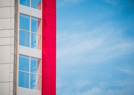 red-blue facade of urban buildings. On a bright sunny day with blue skyの写真素材