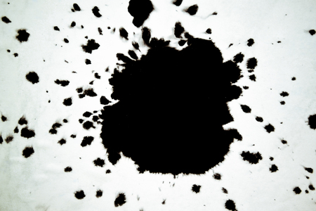Black Ink Conveyed Over White Close-up Paper. Abstract Background isolated on white background. Ink Stains Spread Out and Absorbed Into the Paper Macro.の写真素材