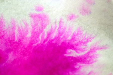 Pink Ink Spread and Absorbed Over White Close-up Paper. Abstract Background. Ink Stains Spread Out and Absorbed Into the Paper Macro.の写真素材