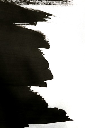 black abstract improvised brush strokes on white paper with one hand isolatedの写真素材