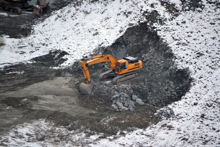 Machine for breaking stones in granite quarry in winter snowy dayの写真素材