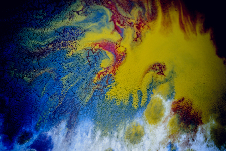 bursts of multicolored paints and mixed together white paper. Drawn splashes of paints of different colors on white surface. Blue, yellow, red, green color. Spreading spraying flow leak stream mixingの写真素材