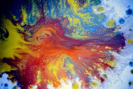 bursts of multicolored paints and mixed together white paper. Drawn splashes of paints of different colors on white surface. Blue, yellow, red, green color. Spreading spraying flow leak stream mixingの写真素材