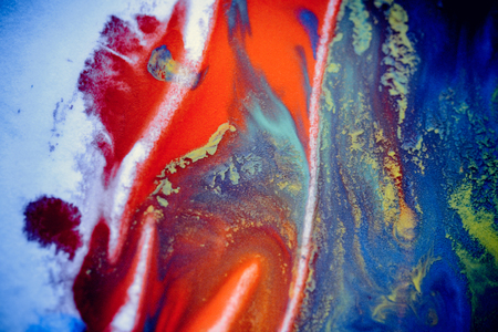 bursts of multicolored paints and mixed together white paper. Drawn splashes of paints of different colors on white surface. Blue, yellow, red, green color. Spreading spraying flow leak stream mixingの写真素材