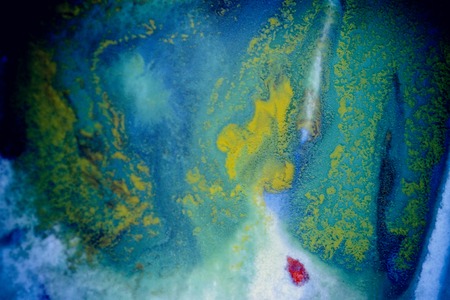bursts of multicolored paints and mixed together white paper. Drawn splashes of paints of different colors on white surface. Blue, yellow, red, green color. Spreading spraying flow leak stream mixingの写真素材