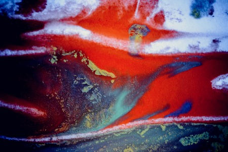 bursts of multicolored paints and mixed together white paper. Drawn splashes of paints of different colors on white surface. Blue, yellow, red, green color. Spreading spraying flow leak stream mixingの写真素材