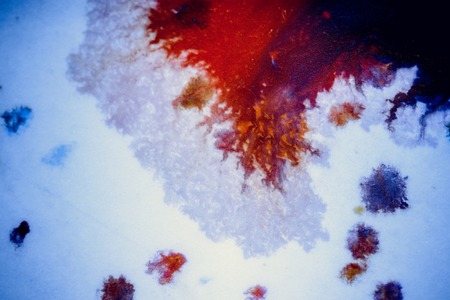 bursts of multicolored paints and mixed together white paper. Drawn splashes of paints of different colors on white surface. Blue, yellow, red, green color. Spreading spraying flow leak stream mixingの写真素材