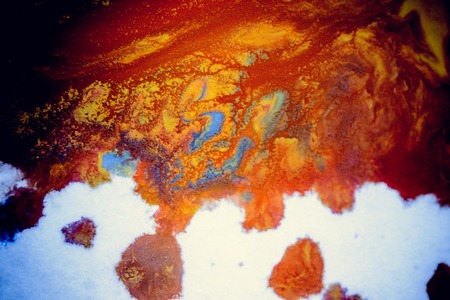 bursts of multicolored paints and mixed together white paper. Drawn splashes of paints of different colors on white surface. Blue, yellow, red, green color. Spreading spraying flow leak stream mixingの写真素材