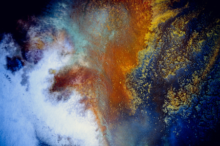 bursts of multicolored paints and mixed together white paper. Drawn splashes of paints of different colors on white surface. Blue, yellow, red, green color. Spreading spraying flow leak stream mixingの写真素材