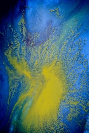 bursts of multicolored paints and mixed together white paper. Drawn splashes of paints of different colors on white surface. Blue, yellow, red, green color. Spreading spraying flow leak stream mixingの写真素材