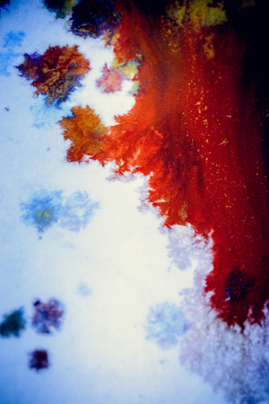 bursts of multicolored paints and mixed together white paper. Drawn splashes of paints of different colors on white surface. Blue, yellow, red, green color. Spreading spraying flow leak stream mixingの写真素材