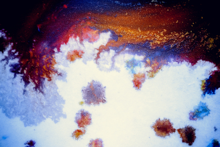 bursts of multicolored paints and mixed together white paper. Drawn splashes of paints of different colors on white surface. Blue, yellow, red, green color. Spreading spraying flow leak stream mixingの写真素材