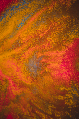 divorces and paint drips red, orange, yellow, blue blurred abstract background on a white paper background plane surface close-up macro with filter toning effectの写真素材