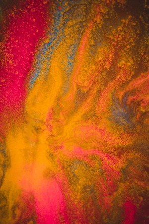 divorces and paint drips red, orange, yellow, blue blurred abstract background on a white paper background plane surface close-up macro with filter toning effectの写真素材