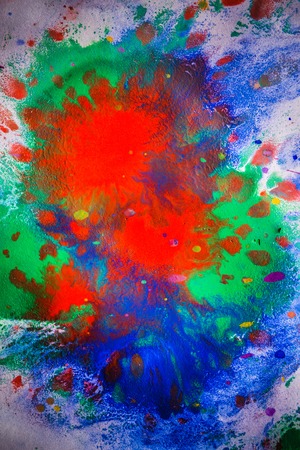 explosive emotional drops of bright red, green, blue on white paperの写真素材