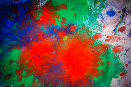 explosive emotional drops of bright red, green, blue on white paperの写真素材