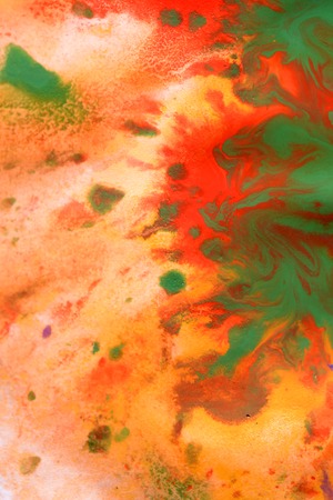 Warm abstract background red, yellow, orange ink spot swith green drops on white paperの写真素材