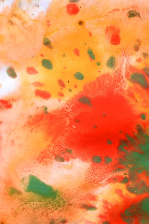 Warm abstract background red, yellow, orange ink spot swith green drops on white paperの写真素材