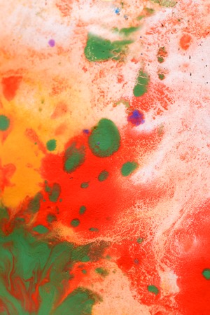 Warm abstract background red, yellow, orange ink spot swith green drops on white paperの写真素材