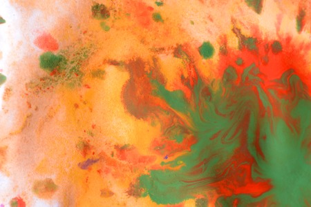 Warm abstract background red, yellow, orange ink spot swith green drops on white paperの写真素材
