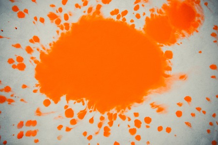 isolated large patches spots blots of splash Orange colors. Orange Ink Conveyed Over White Close-up Paper. Abstract Background. Ink Orange Stains Spread Out and Absorbed Into the Paper Macro.の写真素材