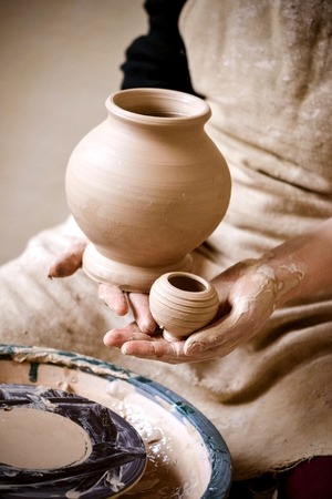 Sculpt Man potter holds palms just made pitchers of different sizes. Potter holds made pots. Workshop pottery. Ceramic skills. Sculptor sculpts products from white clay. Ukraine, national traditionsの写真素材
